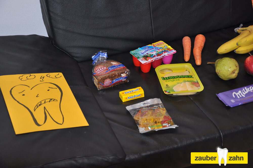 Verschiedene Lebensmittel, darunter Möhren und verpackte Produkte, auf einem Sofa.