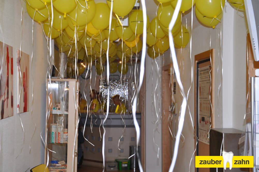 Flur der Praxis mit zahlreichen gelben Luftballons und herabhängenden Bändern.