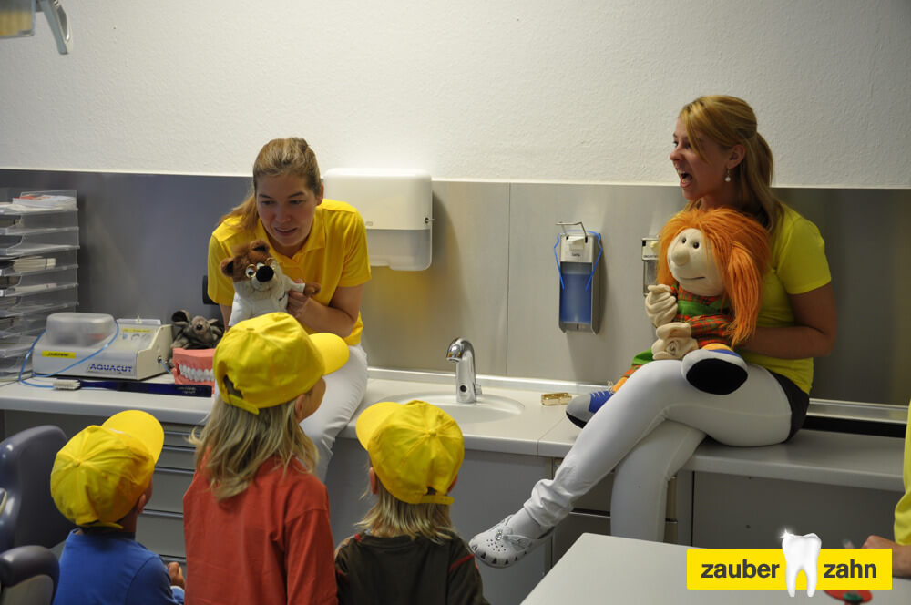Mitarbeiterin spielen mit den Handpuppen vor den Kindern.