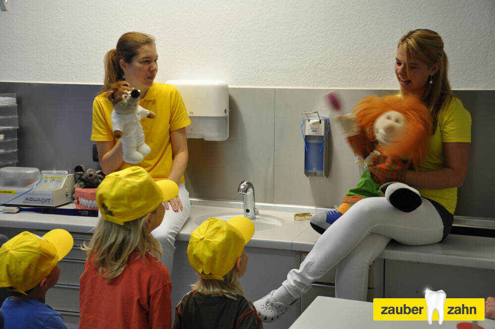 Mitarbeiterin spielen mit den Handpuppen vor den Kindern.