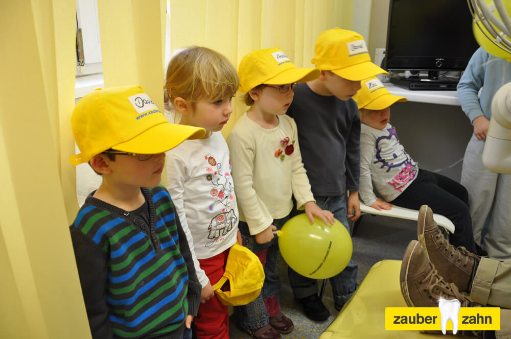Mehrere Kinder stehen gemeinsam im Behandlungszimmer und schauen zu.