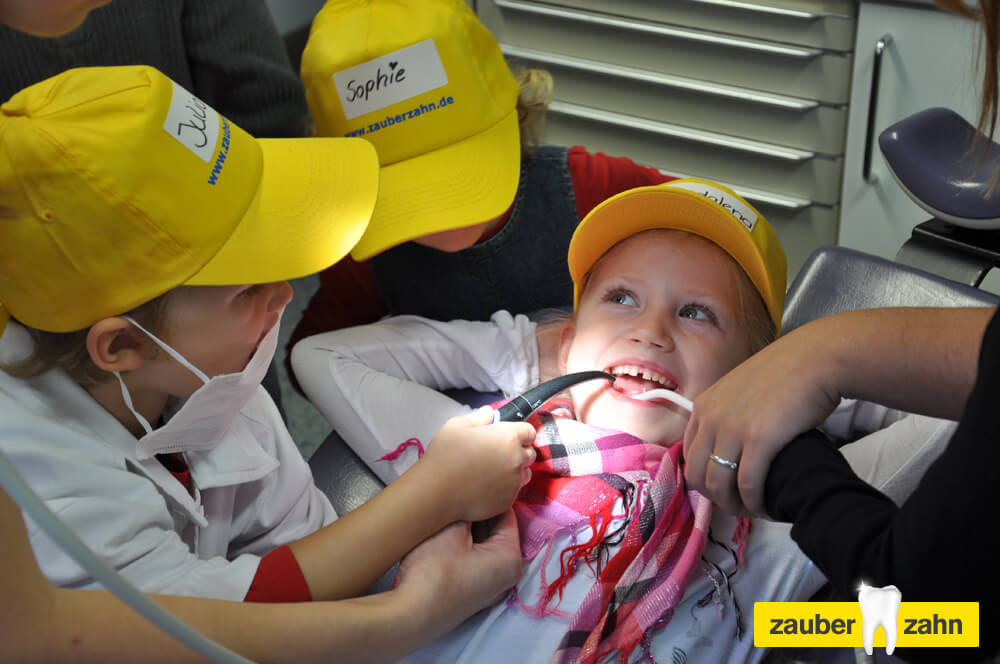 Kinder probieren gegenseitig zahnärztliche Instrumente im Mund aus.