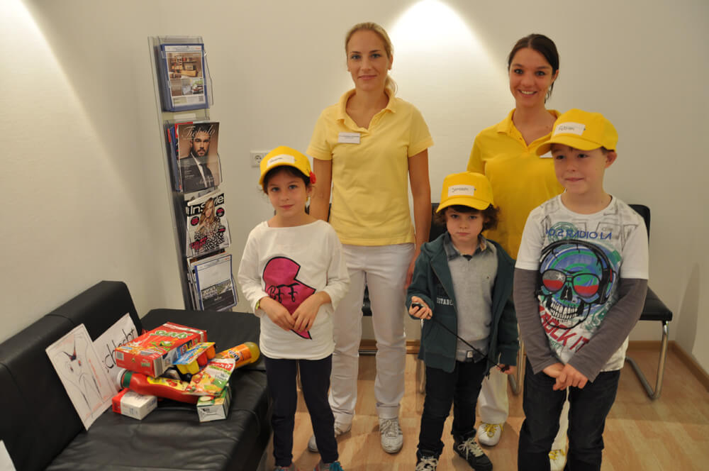 Zwei Mitarbeiterinnen stehen gemeinsam mit drei Kindern für ein Gruppenfoto.