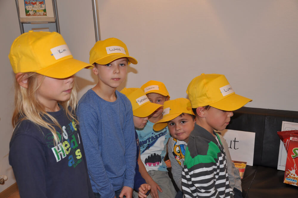 Gruppe von Kindern mit gelben Kappen.