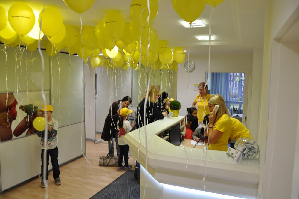 Empfangsbereich der Zahnarztpraxis mit zahlreichen gelben Luftballons.